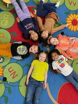 Kindergarten students laying on the floor